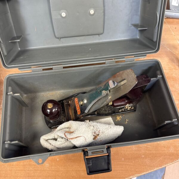 Vintage Stanley wood plane inside a small plastic toolbox.