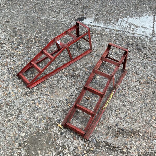 Pair of used steel car ramps for automotive work.