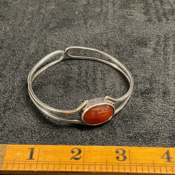 Close-up of a vintage sterling silver bracelet with amber stone.