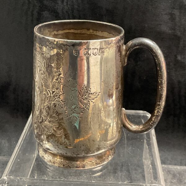 Antique sterling silver tankard with floral engraving and hallmarked detail.