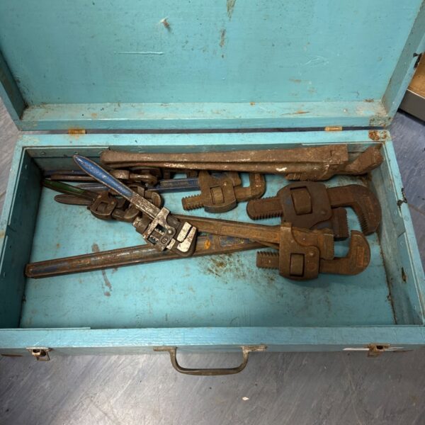Vintage Stilson wrenches in a wooden box, ideal for tool collectors.