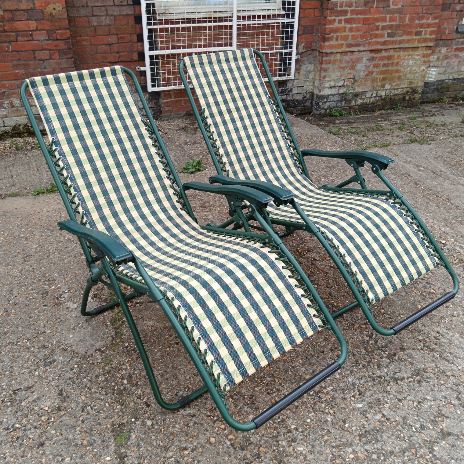 Vintage striped reclining garden chairs in a garden setting.