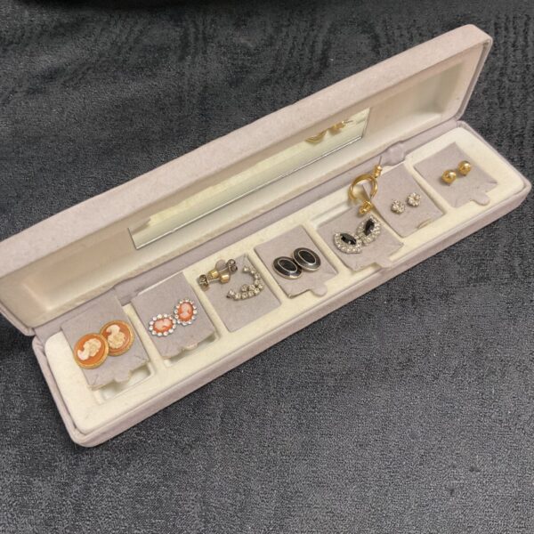 Assorted stud earrings displayed in a mirrored case.