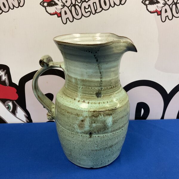 Vintage studio pottery pitcher with green fat lava glaze.
