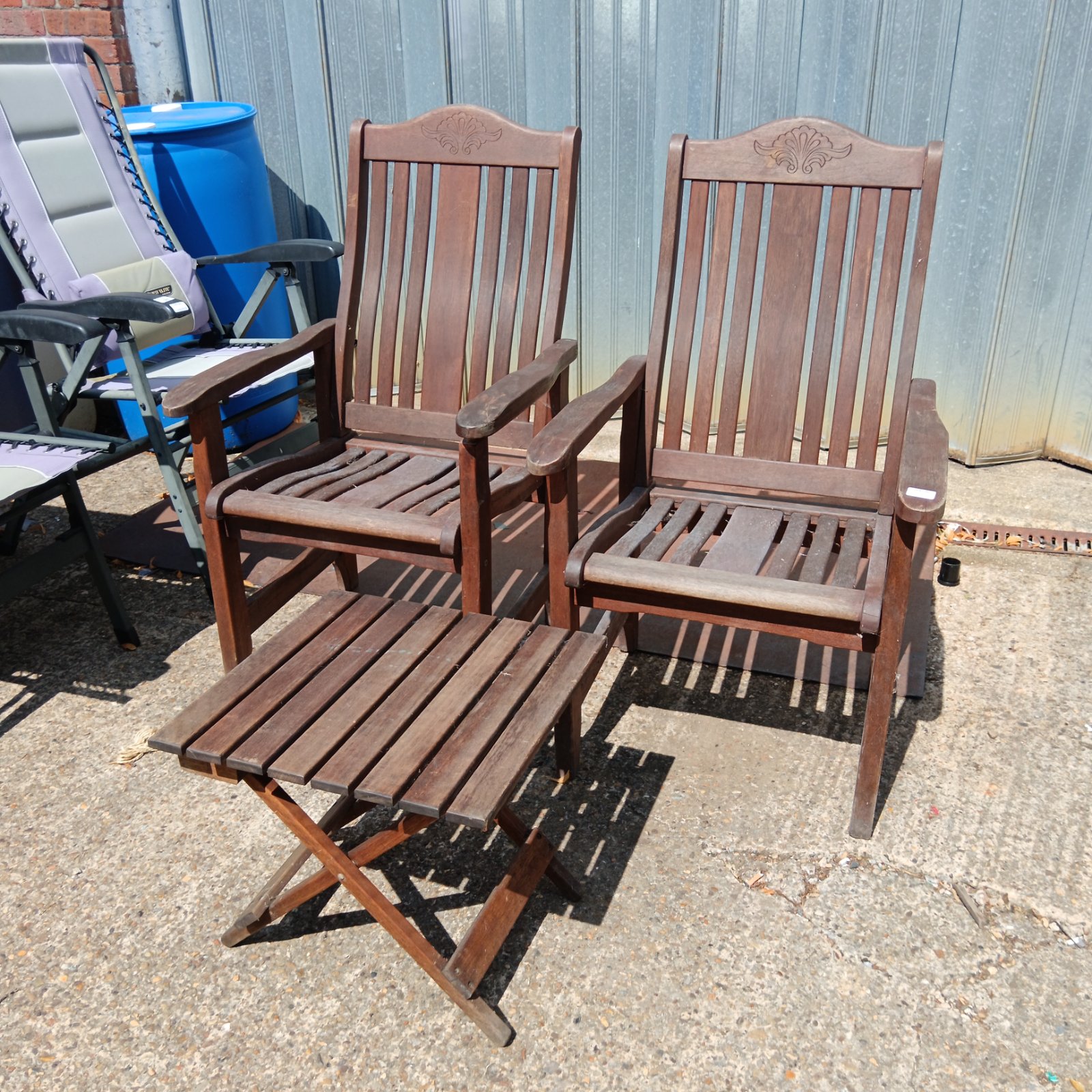 Teak garden furniture set with two folding chairs and a table.