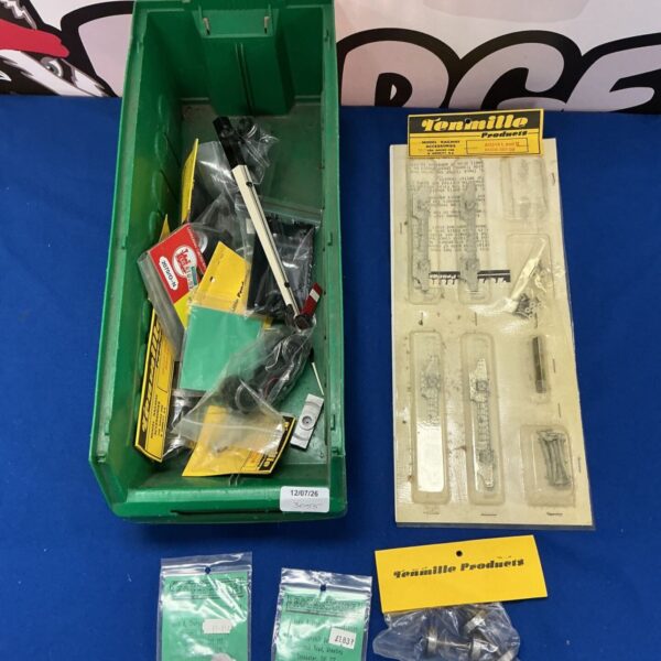 Assortment of Tenmille model railway accessories in a plastic container.