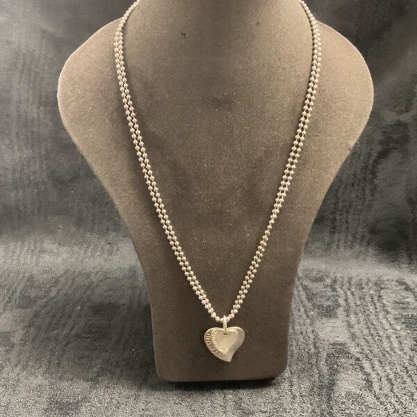 Close-up of Tiffany silver heart pendant necklace on display.
