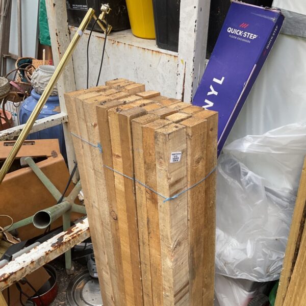 Three bundles of 4ft timber in a garden setting.
