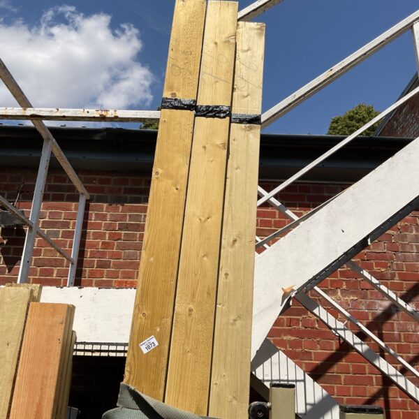 Three bundles of 9’6” timber stacked outdoors, ready for building projects.