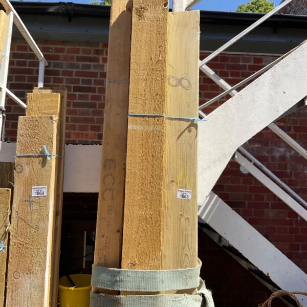Three bundles of 8ft timber stacked outdoors, ready for use.