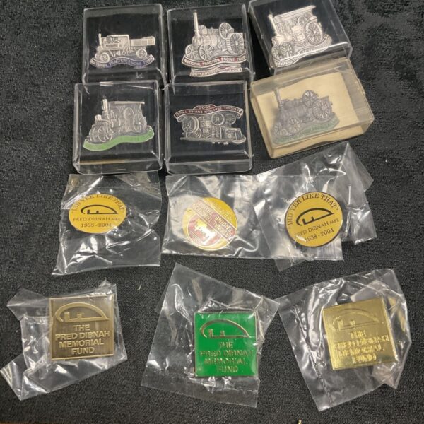 Collection of vintage traction engine and Fred Dibnah pin badges.