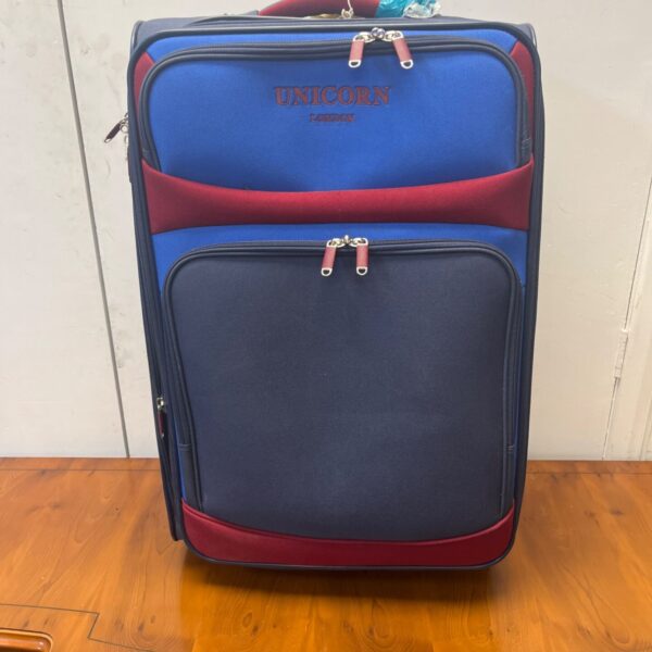 Red and navy Unicorn London suitcase on wheels.