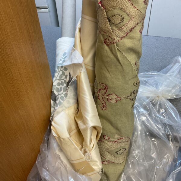 Three rolls of vintage upholstery fabric in varying colours.