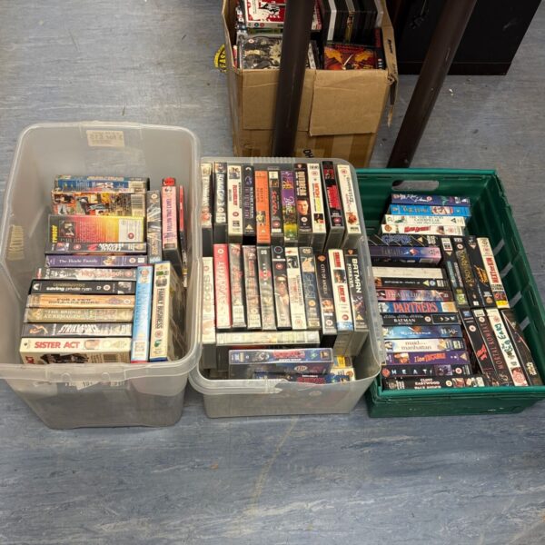 Lot of vintage VHS movie tapes in plastic cases.