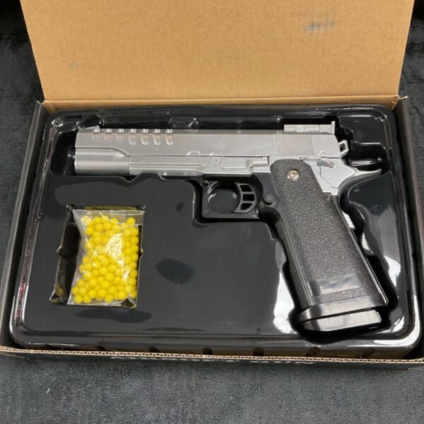 Silver Vigor airsoft pistol with BBs in open box.