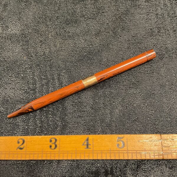 Vintage 9ct gold banded propelling pencil on textured background.