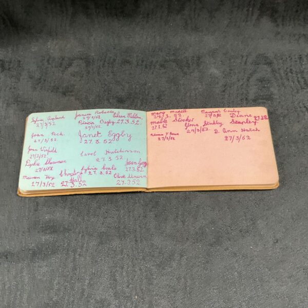 Vintage autograph book with handwritten signatures, collectible memorabilia.