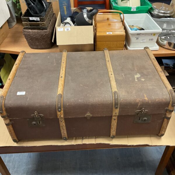 Vintage brown travel trunk with wooden corner protectors.