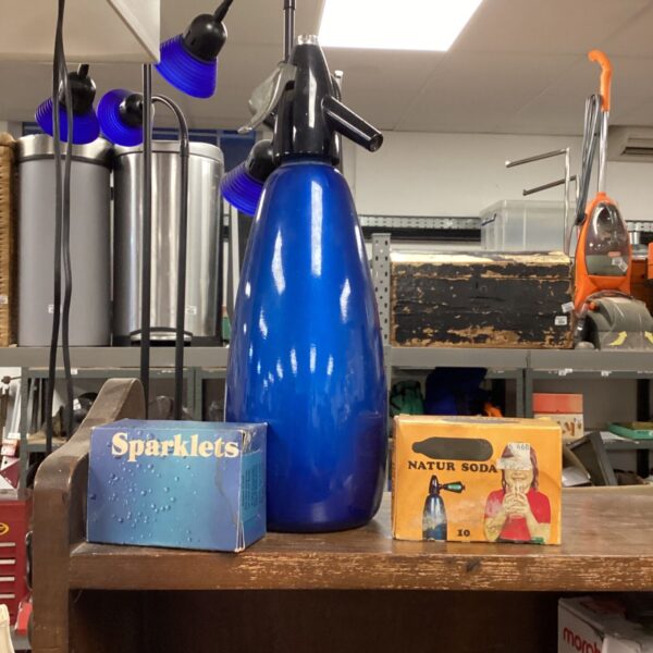 Vintage blue soda syphon with capsules for carbonated water.