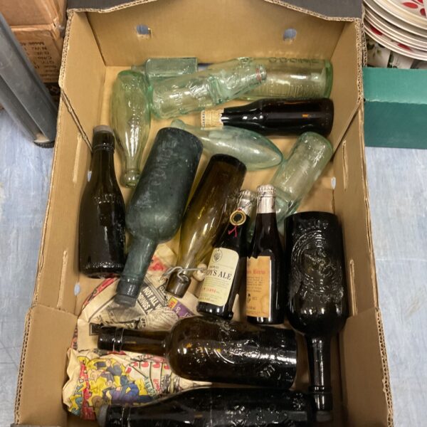 Assortment of vintage glass bottles in a cardboard tray.