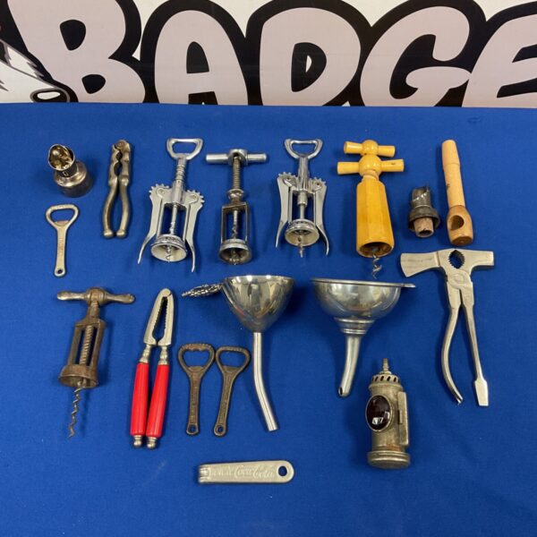 Vintage collection of metal bottle openers including Coca Cola branding.