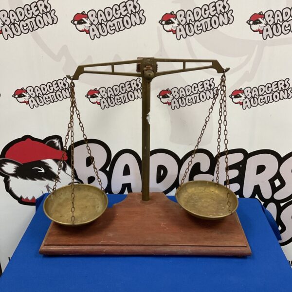 Front view of vintage brass 3lb balance scales on a blue surface.
