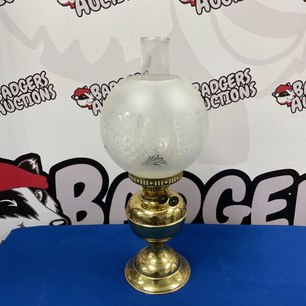 Vintage brass oil lamp with glass shade, a classic antique lighting piece.