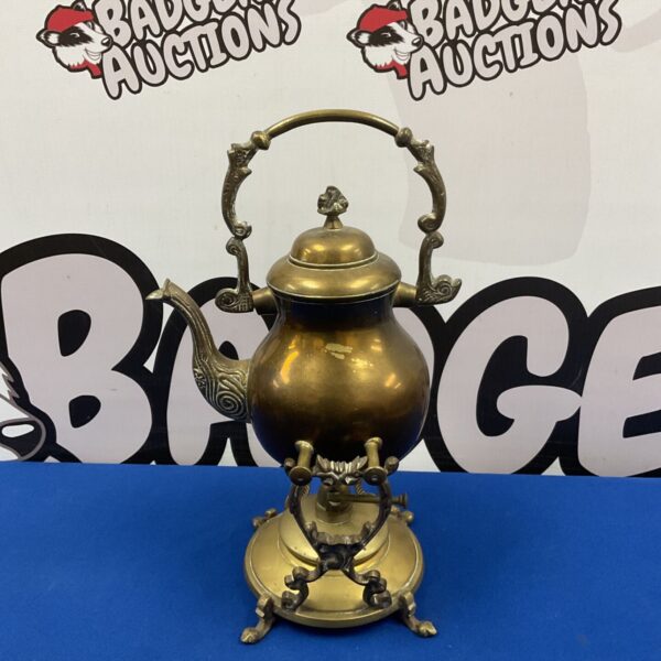 Ornate vintage brass spirit kettle on a stand.