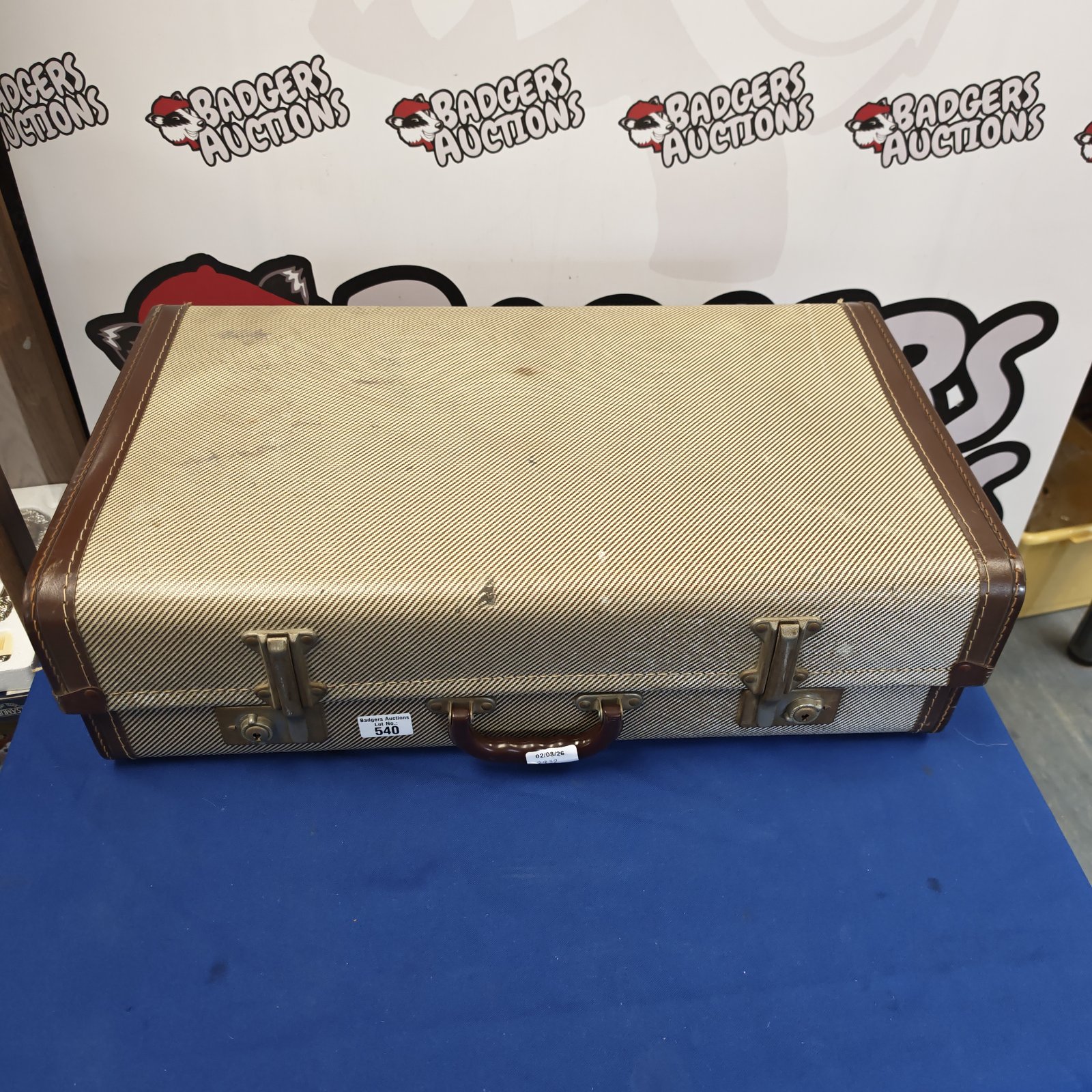 Vintage brown suitcase with a worn exterior and handle.