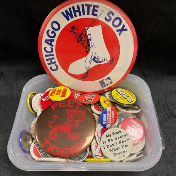 A tub filled with a large collection of vintage button badges.