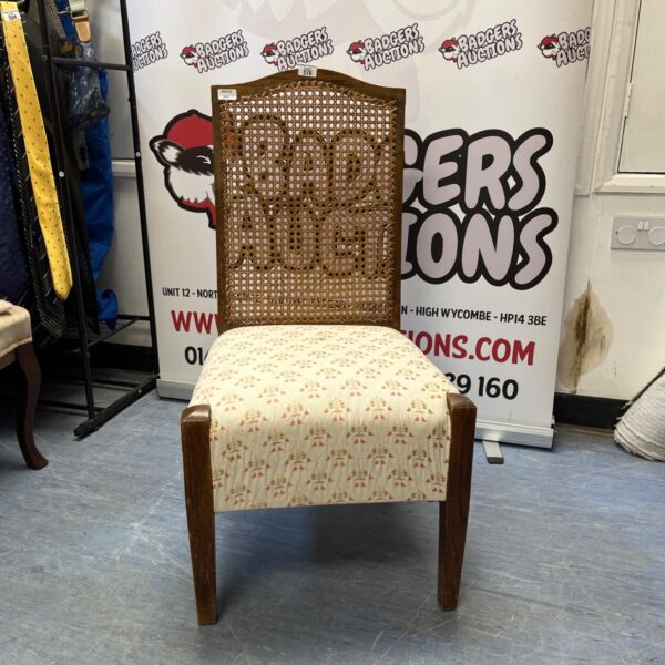 Vintage dining chair with cane back and patterned upholstery.