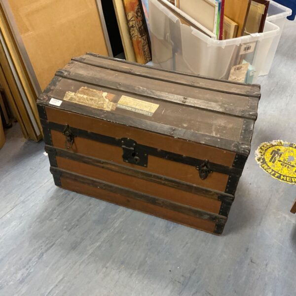 Front view of a weathered vintage canvas chest.