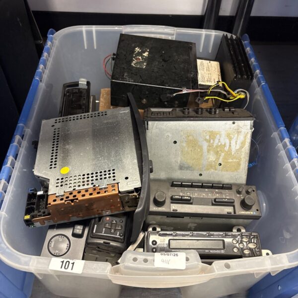 Collection of vintage car stereos and radios in a box.