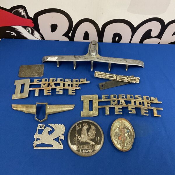 Vintage car and tractor badges including Bedford and Ford emblems.