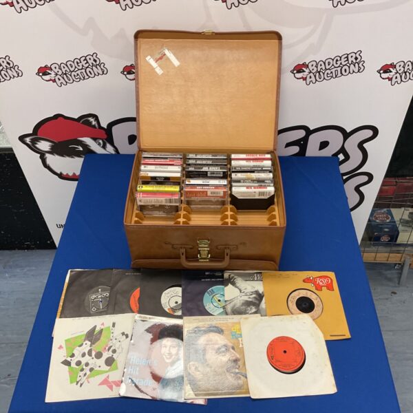 Vintage transit case filled with cassette tapes and vinyl records.