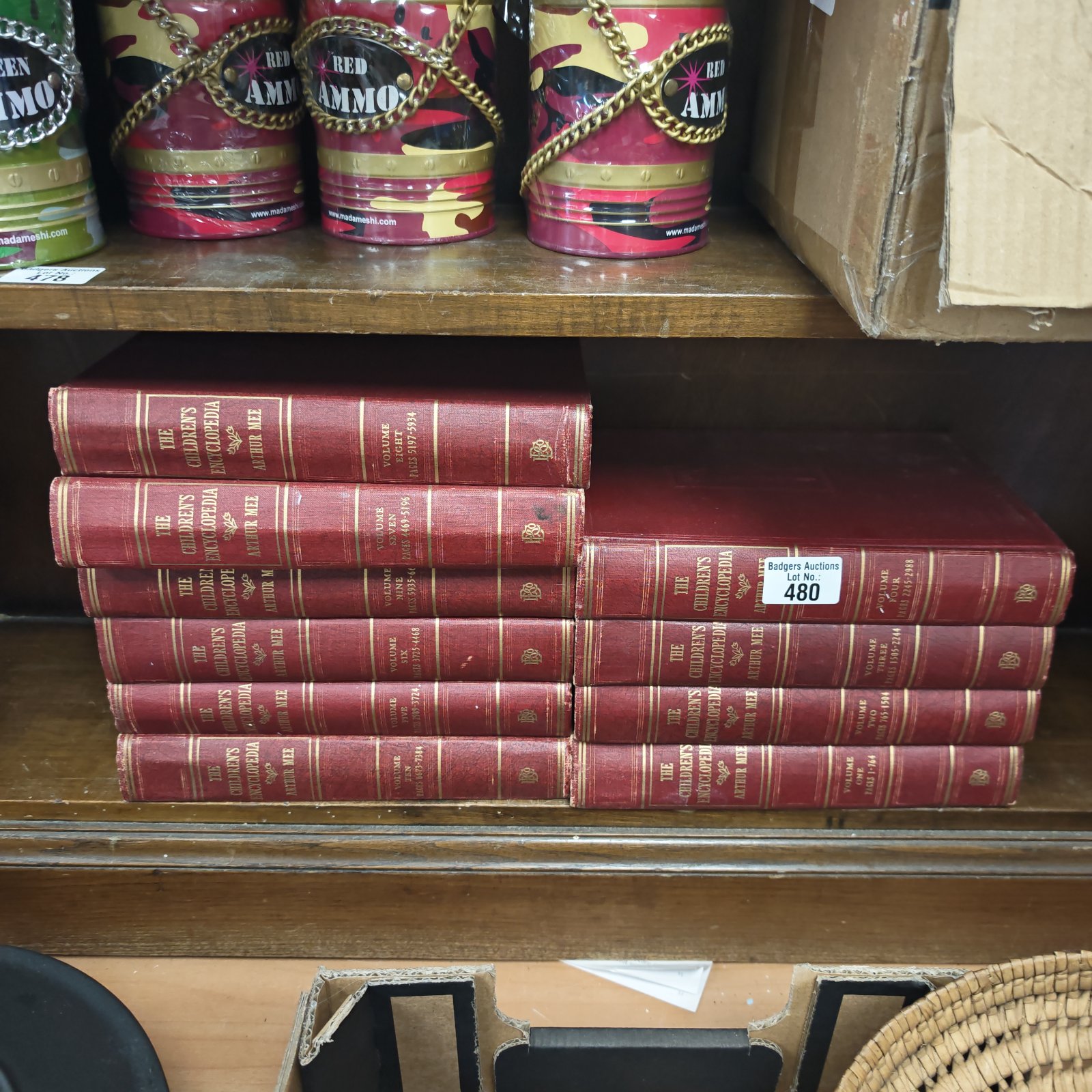 Vintage red children's encyclopedia collection on a shelf.