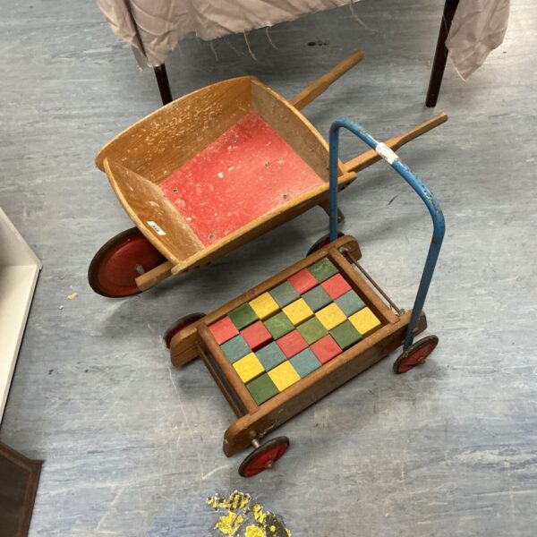 Vintage wooden child’s wheelbarrow with colourful building blocks.