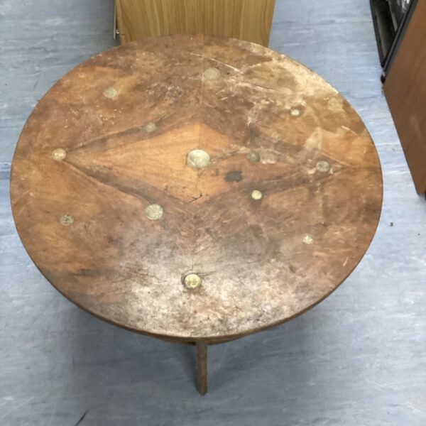 Vintage round coffee table with coin inlay detail.