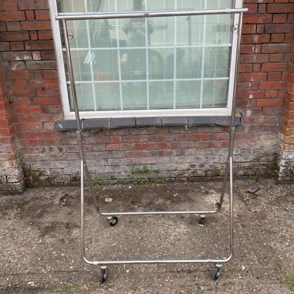Vintage collapsible clothes rail with castors for easy movement.