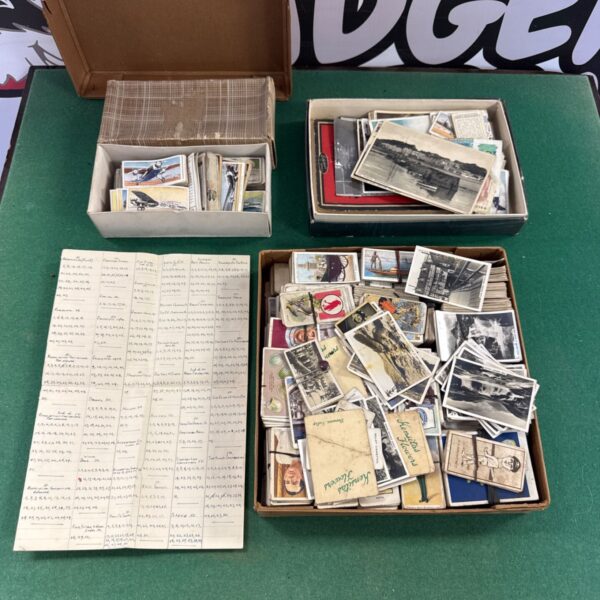 Vintage collectors cards and album on a green table.