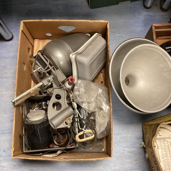Vintage darkroom enlarger with components in a cardboard box.