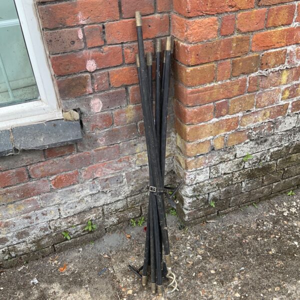 Vintage drain snake with four interconnected metal rods.