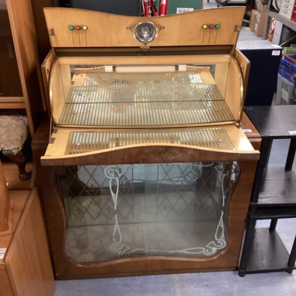 Vintage drinks cabinet with glass front and wooden frame.