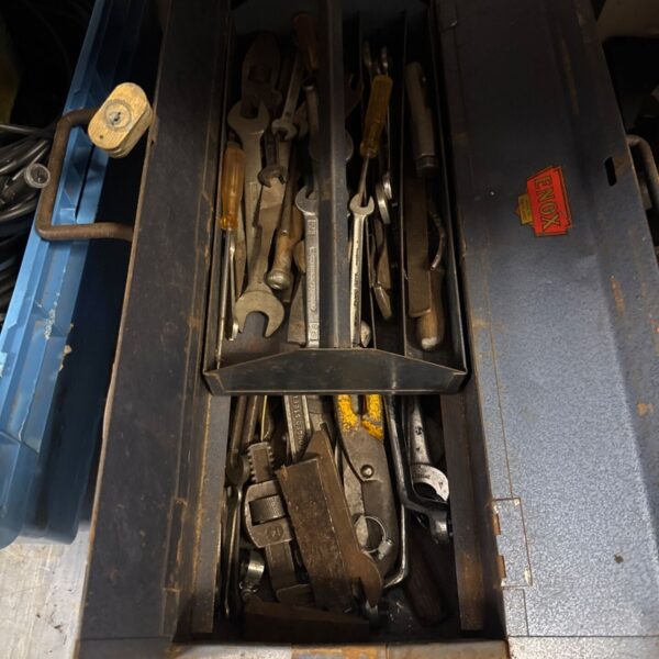 Vintage Enox metal toolbox filled with various hand tools.