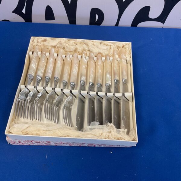 Vintage boxed fish fork and knife set with cream handles.
