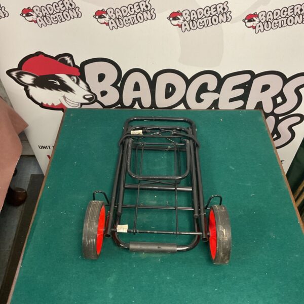 Vintage foldable luggage cart with metal frame and wheels.