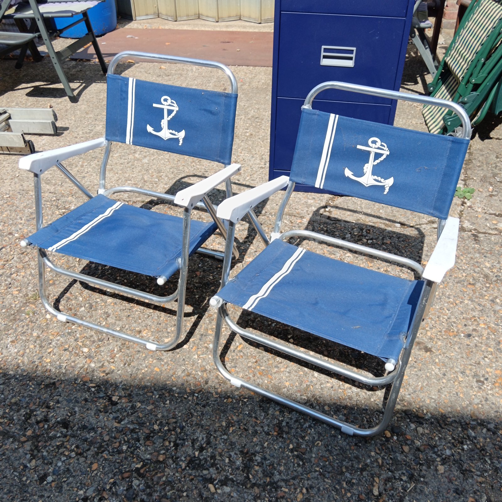 Vintage folding boat deck chairs with blue canvas and anchor design.