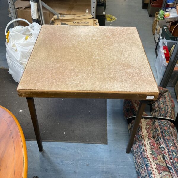 Vintage folding card table with laminate top and metal legs.