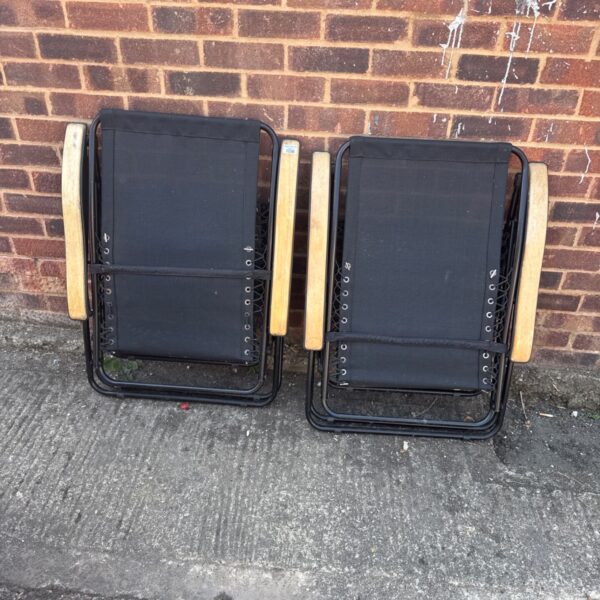 Vintage folding garden loungers with wooden frames and canvas seats.