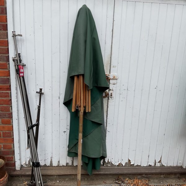 Large vintage garden parasol with green canvas canopy.